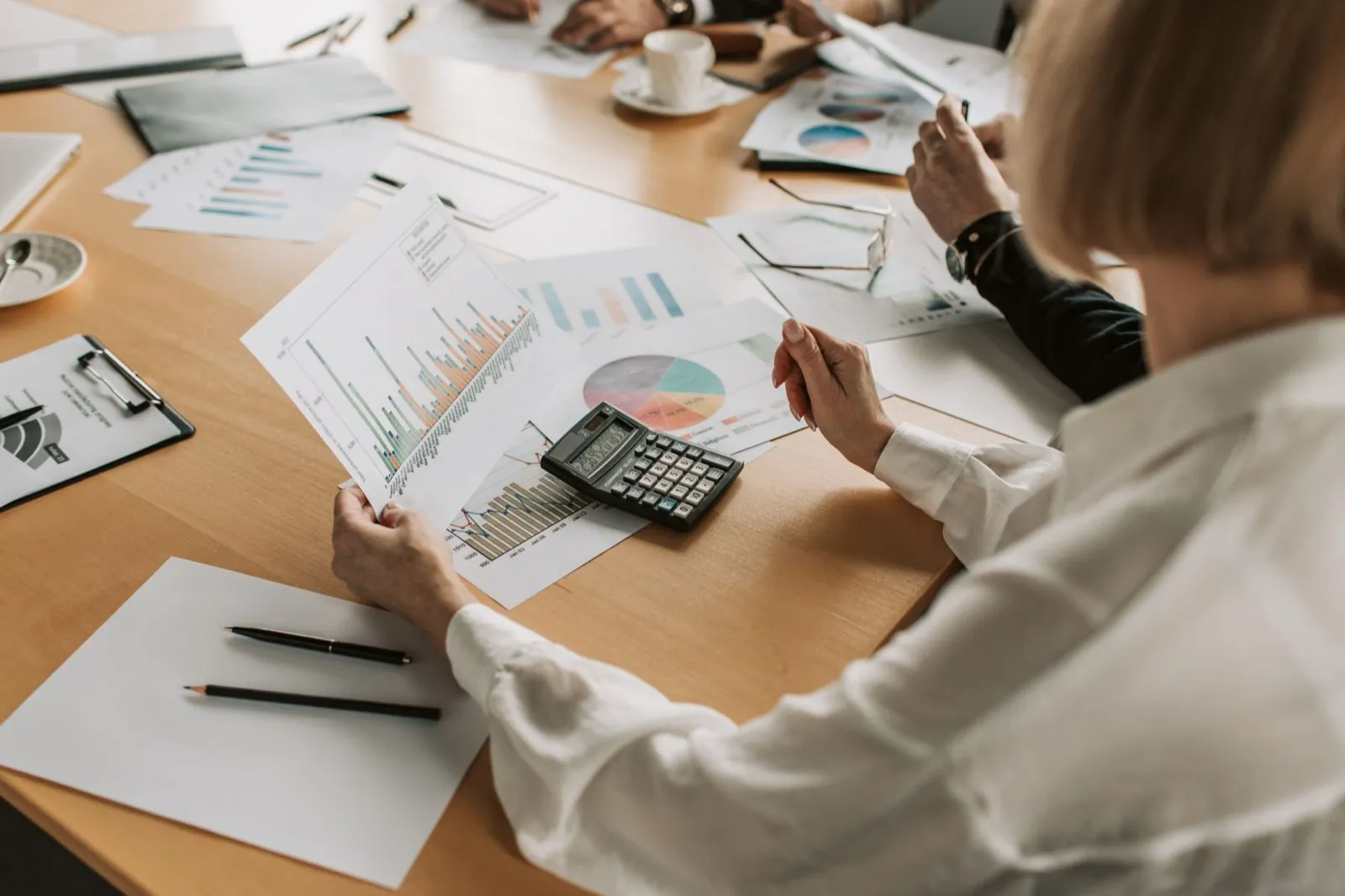 Reunião com relatórios e gráficos sobre a mesa