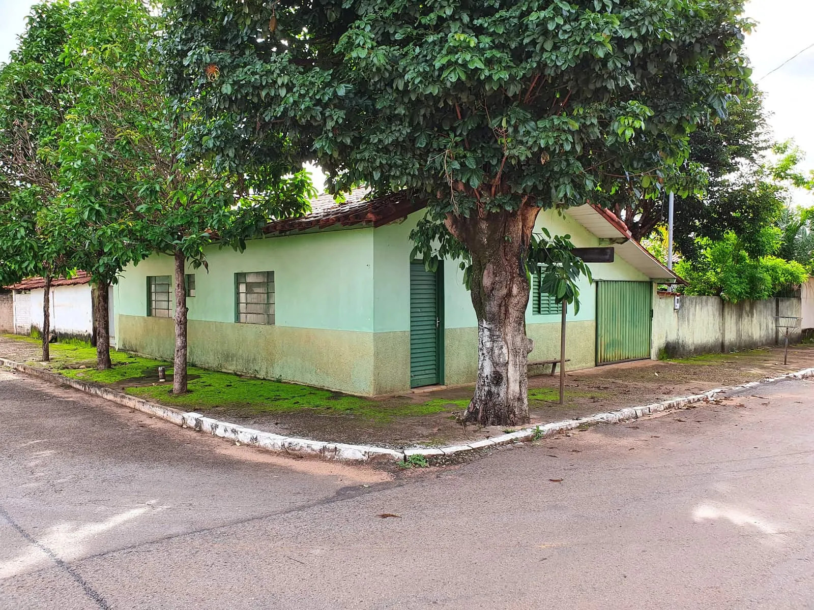 Casa térrea na esquina de uma rua tranquila, sob a sombra das árvores