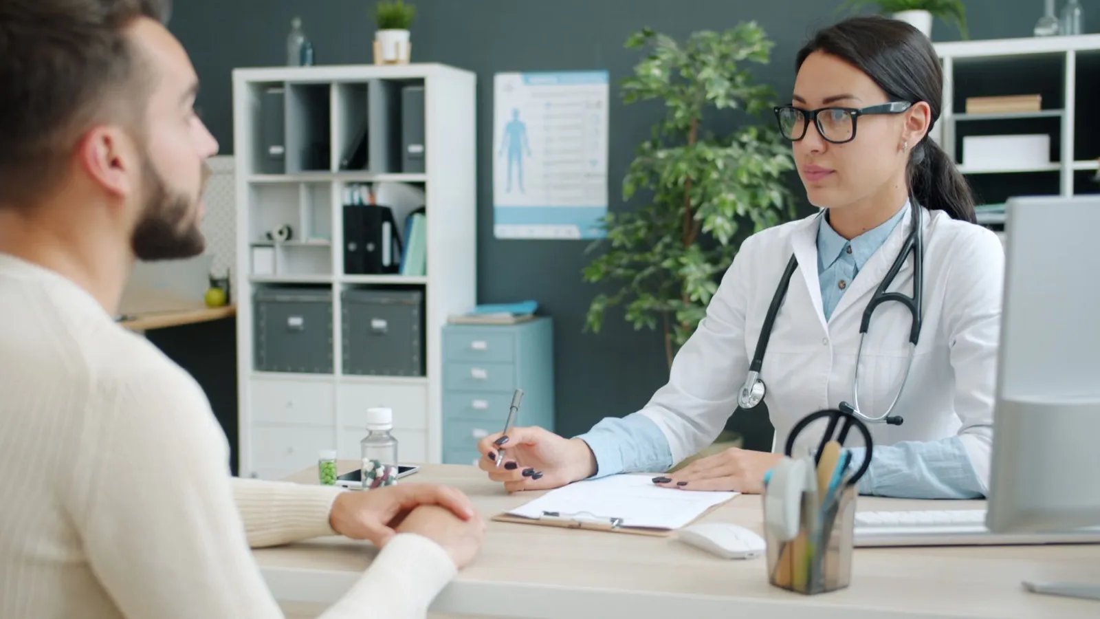 Consulta em consultório médico, com a médica à mesa