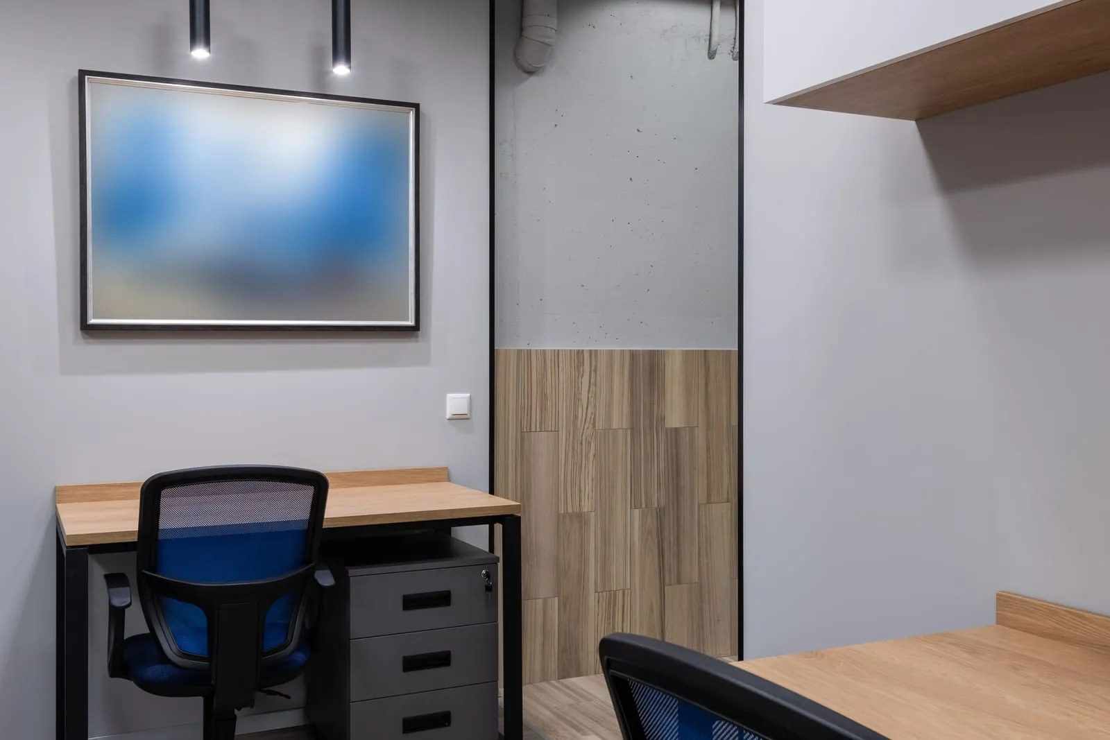 Escritório pequeno vazio, com mesa, cadeira e gaveteiro